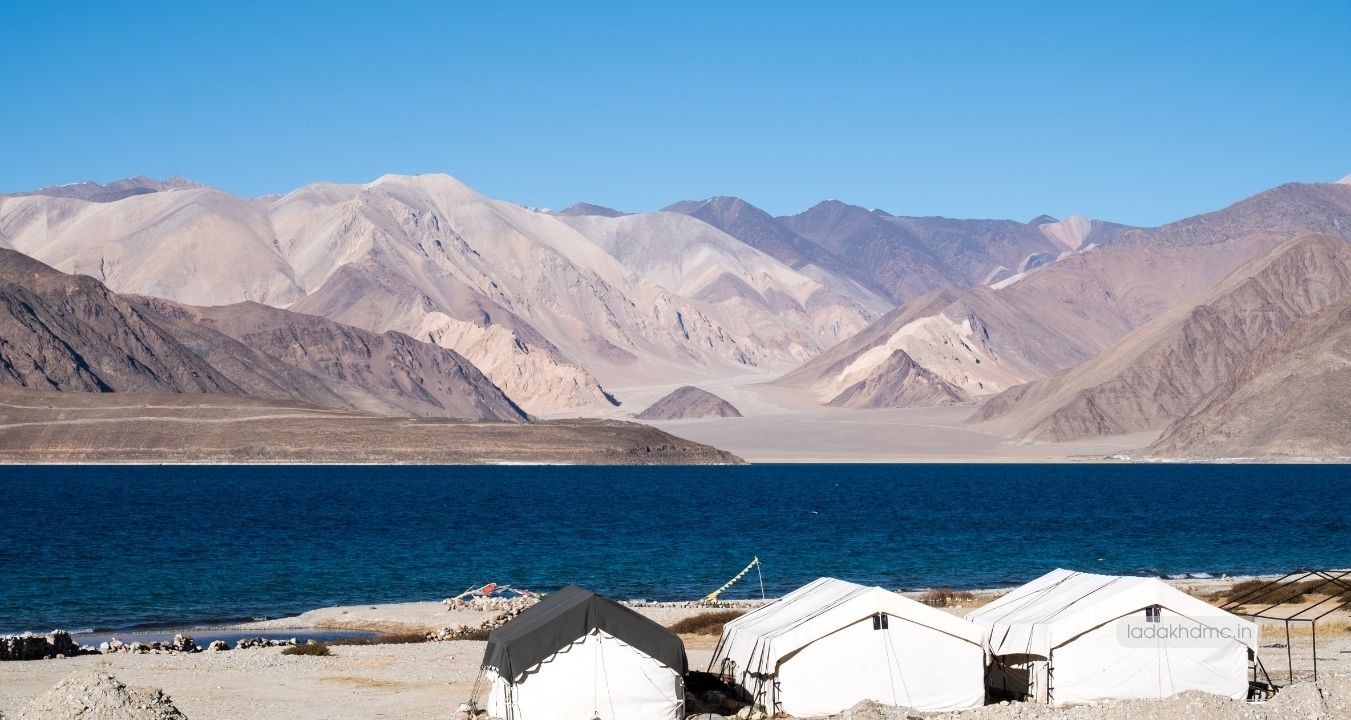 Panoramic view of Pangong Tso Lake with vast blue waters and mountains in Ladakh