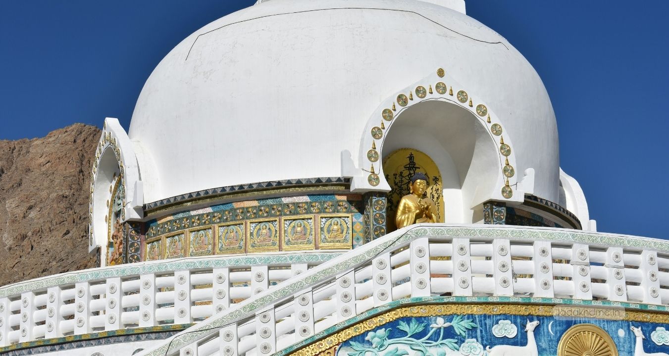 Panoramic view of Shanti Stupa in Leh, Ladakh with barren hills, white stupa structure, and blue skies
